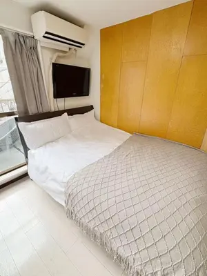 a bedroom with a bed and a flat screen tv at Asakusa Sakura-3F in Tokyo