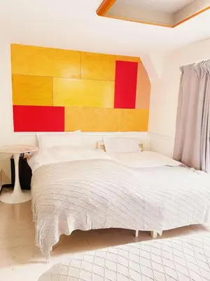 a bedroom with a large bed with a colorful headboard at Asakusa Sakura-3F in Tokyo
