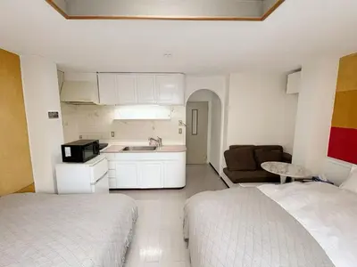a room with a bed and a kitchen and a couch at Asakusa Sakura-3F in Tokyo