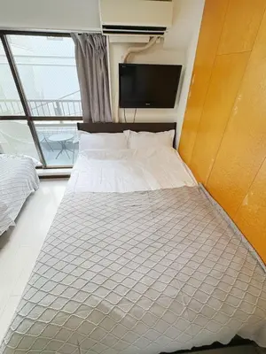 a large bed in a room with a tv at Asakusa Sakura-3F in Tokyo