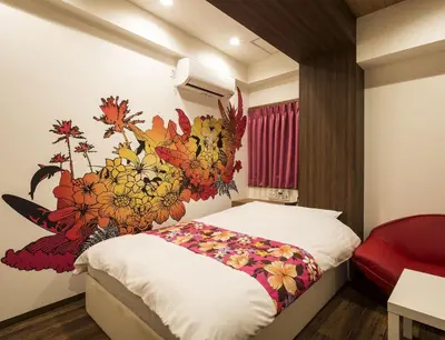 a bedroom with a bed with a flower mural on the wall at Hotel La'i ローレル Adult only in Tokyo