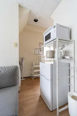 a room with a white refrigerator and a microwave at \u30a2\u30f3\u30c9\u30b9\u30c6\u30a4\u6c38\u798f3\u4e01\u76ee201 in Tokyo