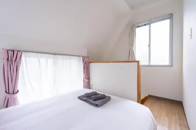 a bedroom with a white bed with a pillow on it at \u30a2\u30f3\u30c9\u30b9\u30c6\u30a4\u6c38\u798f3\u4e01\u76ee201 in Tokyo