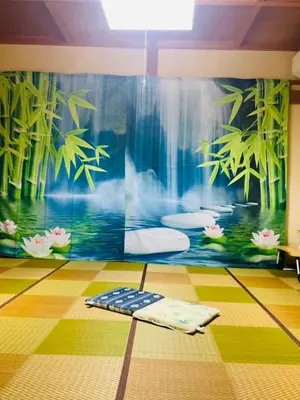 a room with a wall with a mural of bamboo at \u4e00\u53f6\u8ed2 \u6771\u4eac\u6c11\u5bbf One-Leaf House in Tokyo