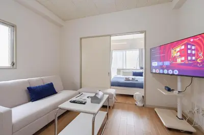 a living room with a white couch and a tv at \u30a2\u30f3\u30c9\u30b9\u30c6\u30a4\u6c38\u798f3\u4e01\u76ee202 in Tokyo