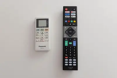 two remote controls sitting next to each other on a table at \u30a2\u30f3\u30c9\u30b9\u30c6\u30a4\u6c38\u798f3\u4e01\u76ee202 in Tokyo