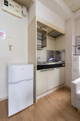 a kitchen with white cabinets and a white refrigerator at \u30a2\u30f3\u30c9\u30b9\u30c6\u30a4\u6c38\u798f3\u4e01\u76ee202 in Tokyo