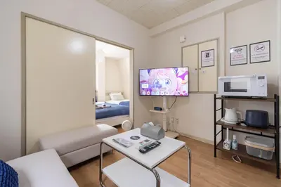 a living room with a couch and a tv at \u30a2\u30f3\u30c9\u30b9\u30c6\u30a4\u6c38\u798f3\u4e01\u76ee202 in Tokyo