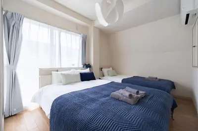 a bedroom with two beds with towels on them at \u30a2\u30f3\u30c9\u30b9\u30c6\u30a4\u6c38\u798f3\u4e01\u76ee202 in Tokyo