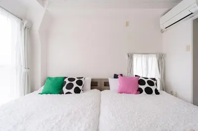 a bedroom with two beds with black and white pillows at \u30a2\u30f3\u30c9\u30b9\u30c6\u30a4\u6c38\u798f3\u4e01\u76ee301 in Tokyo