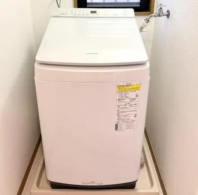 a white refrigerator in a corner of a room at R&J Guest House, 2LDK, 5 min to JR Hirai, Direct to Akihabara and Shinjuku in Tokyo