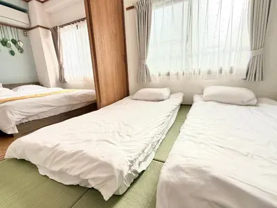 two beds in a room with white sheets at R&J Guest House, 2LDK, 5 min to JR Hirai, Direct to Akihabara and Shinjuku in Tokyo