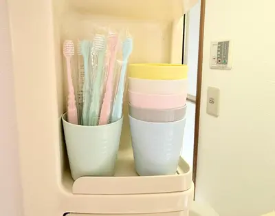 a refrigerator filled with cups and toothbrushes at R&J Guest House, 2LDK, 5 min to JR Hirai, Direct to Akihabara and Shinjuku in Tokyo