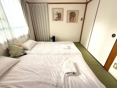 a hotel room with two beds and a window at R&J Guest House, 2LDK, 5 min to JR Hirai, Direct to Akihabara and Shinjuku in Tokyo