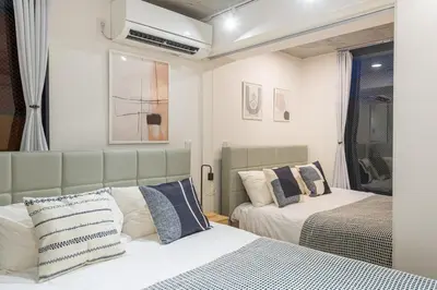 a bedroom with two beds and a mirror at trias815 \u5e73\u548c\u5cf6102\u53f7\u5ba4 in Tokyo