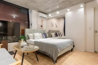 a bedroom with a bed and a table and a couch at trias815 \u5e73\u548c\u5cf6102\u53f7\u5ba4 in Tokyo