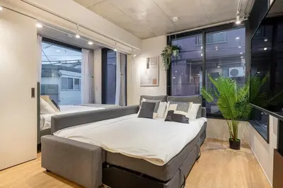 a bedroom with a large bed and a couch at trias815 \u5e73\u548c\u5cf6201\u53f7\u5ba4 in Tokyo
