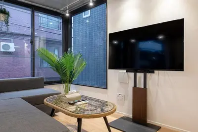 a living room with a flat screen tv on a wall at trias815 \u5e73\u548c\u5cf6201\u53f7\u5ba4 in Tokyo