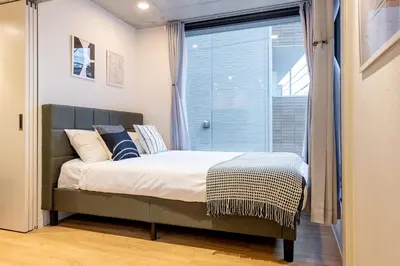 a bedroom with a bed and a large window at trias815 \u5e73\u548c\u5cf6201\u53f7\u5ba4 in Tokyo