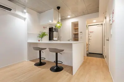 a kitchen with two bar stools and a counter at trias815 \u5e73\u548c\u5cf6201\u53f7\u5ba4 in Tokyo