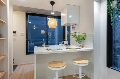 a kitchen with a sink and two stools at trias815 \u5e73\u548c\u5cf6202\u53f7\u5ba4 in Tokyo