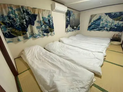 two white beds in a room with blue and white paintings at \u6d45\u8349 \u30b9\u30ab\u30a4\u30c4\u30ea\u30fc\u570f10\u5206 \u4ea4\u901a\u81f3\u4fbf \u6d45\u8349\u5bfa\u89b3\u5149 \u53cc\u9b5a\u306e\u5bbf \u4eac\u5cf6 in Tokyo
