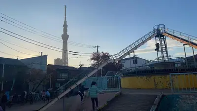a group of people walking down a stairs with a tower in the background at \u6d45\u8349 \u30b9\u30ab\u30a4\u30c4\u30ea\u30fc\u570f10\u5206 \u4ea4\u901a\u81f3\u4fbf \u6d45\u8349\u5bfa\u89b3\u5149 \u53cc\u9b5a\u306e\u5bbf \u4eac\u5cf6 in Tokyo