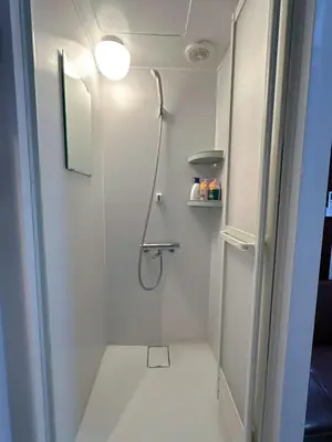 a white bathroom with a shower and a toilet at \u6d45\u8349 \u30b9\u30ab\u30a4\u30c4\u30ea\u30fc\u570f10\u5206 \u4ea4\u901a\u81f3\u4fbf \u6d45\u8349\u5bfa\u89b3\u5149 \u53cc\u9b5a\u306e\u5bbf \u4eac\u5cf6 in Tokyo