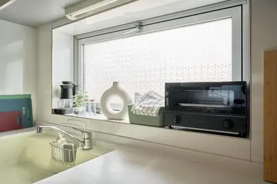 a kitchen with a window with a microwave on a counter at Fuufu House Tokyo Yotsuya - No Elevator 3F WalkUp in Tokyo