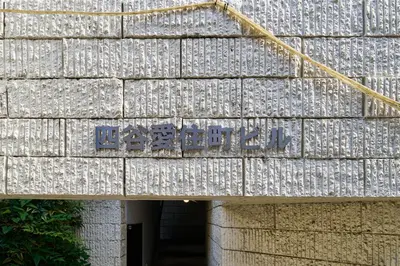 a sign on the side of a stone building at Fuufu House Tokyo Yotsuya - No Elevator 3F WalkUp in Tokyo