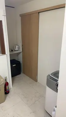 a kitchen with a door open to a kitchen with a stove at \u53cc\u9b5a\u306e\u5bbf\u6c60\u888b in Tokyo