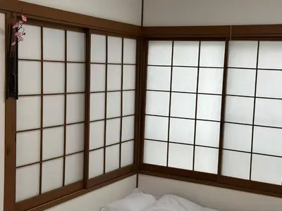 a room with four windows and a bed at \u53cc\u9b5a\u306e\u5bbf\u6c60\u888b in Tokyo