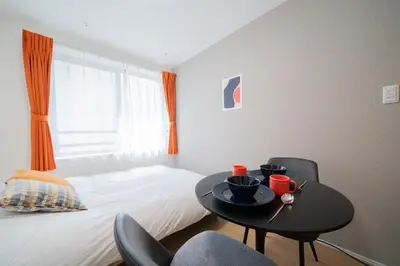 a bedroom with a table with two chairs and a bed at PRIME Asakusa - Vacation STAY 20535 in Tokyo