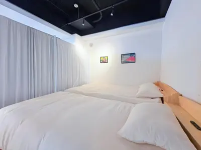 a bedroom with two beds with white sheets at GARDEN HOUSE Tameike-Sanno in Tokyo