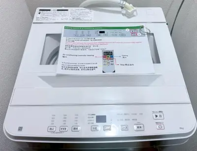 a washing machine with a box on top of it at GARDEN HOUSE Tameike-Sanno in Tokyo