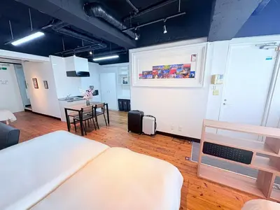 a room with a bed and a table and chairs at GARDEN HOUSE Tameike-Sanno in Tokyo