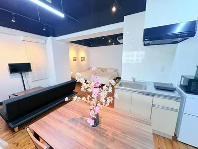 a kitchen with a couch and a table with flowers at GARDEN HOUSE Tameike-Sanno in Tokyo