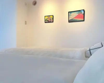 a white room with three pictures on the wall at GARDEN HOUSE Tameike-Sanno in Tokyo