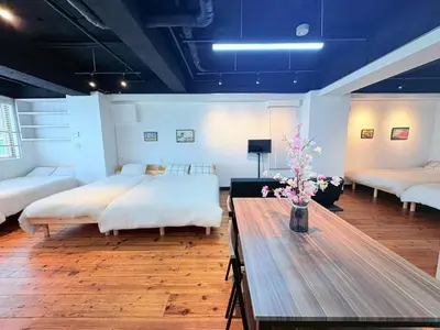 a room with two beds and a table with flowers at GARDEN HOUSE Tameike-Sanno in Tokyo
