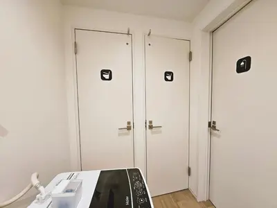 two white doors in a room with a phone at Hermitage Hotel Nishishin in Tokyo