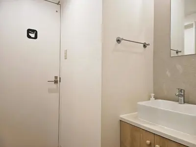 a bathroom with a sink and a glass shower door at Hermitage Hotel Nishishin in Tokyo
