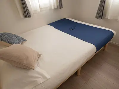 a large bed with a blue and white blanket on it at \u685c\u306e\u5ddd70-41 \u7a32\u8377\u753a\u99c5 \u8fd1\u4e0a\u91ce-\u6d45\u8349 2-8\u4eba\u4e28 Inaricho Station, Near Ueno, Asakusa 2-8 people in Tokyo