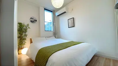 a bedroom with a white bed and a window at A home that captures the colors and spirit of Japan in Tokyo