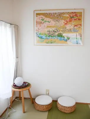 a room with two stools and a painting on the wall at Ayaka House Hirai in Tokyo
