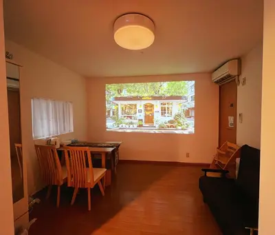 a living room with a table and chairs and a window at Ayaka House Hirai in Tokyo