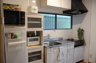 a kitchen with white cabinets and a sink at Ayaka House Hirai in Tokyo
