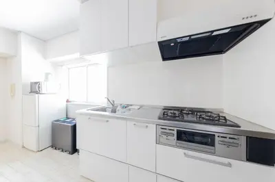 a white kitchen with a stove and a refrigerator at \u30a8\u30c9\u30e2\u30c0\u30f3\u30b9\u30c6\u30a4 Edo Modern Stay 01 in Tokyo