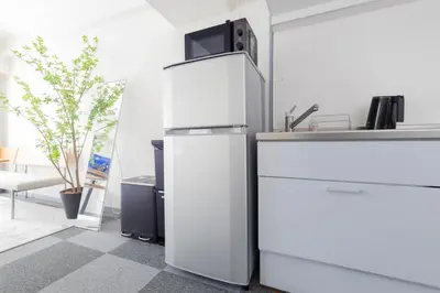 a white refrigerator in a kitchen with a sink at \u30a8\u30c9\u30e2\u30c0\u30f3\u30b9\u30c6\u30a4 Edo Modern Stay 01 in Tokyo