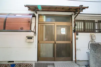 a wooden door on a house with a fence at Family Stay & Relaxation -Tokyo East- in Tokyo