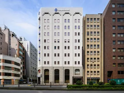 a white building in the middle of some buildings at Villa Fontaine Tokyo Hibiya in Tokyo